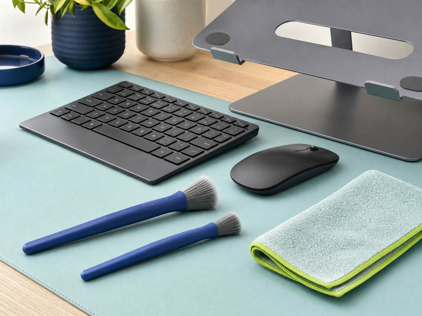 Soft manual detail brushes beside an unplugged keyboard on a tidy apartment desk.